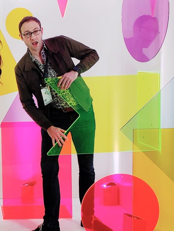 Jesse hiding behind colorful acrylic shapes