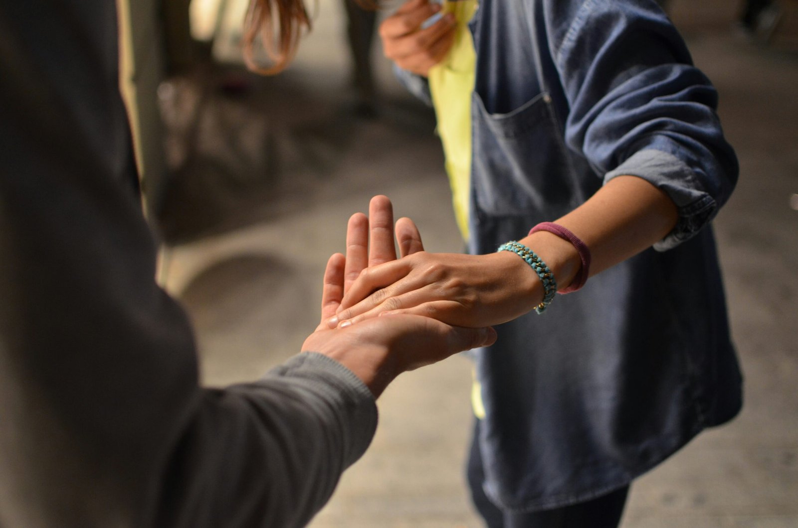 A person holding the hand of another, helping them out. Photo by Rémi Walle on Unsplash