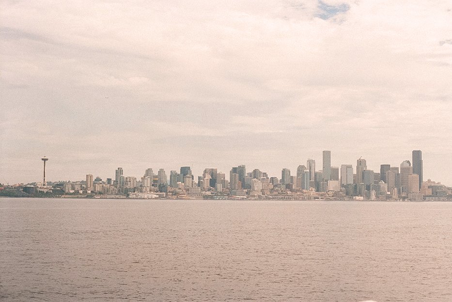 Seattle’s skyline across calm water. Photo credit, Hans on Unsplash.